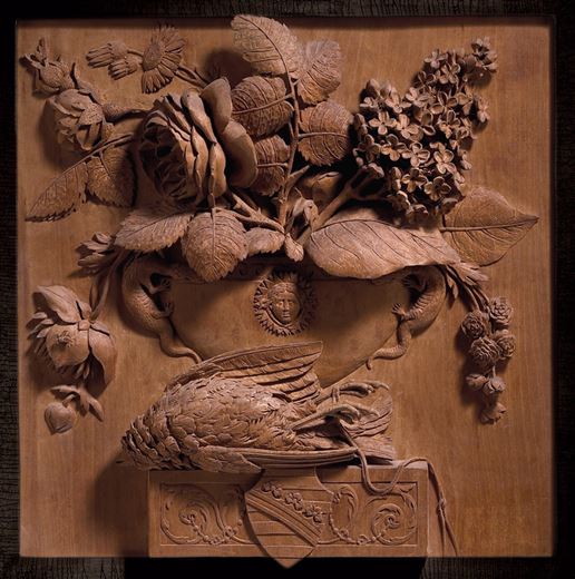 The Wettin Still-Life: Carved panel relief still life with a bird and a vase containing roses, lilacs, daisies and ranunculi, resting on a ledge bearing the arms of the House of Wettin